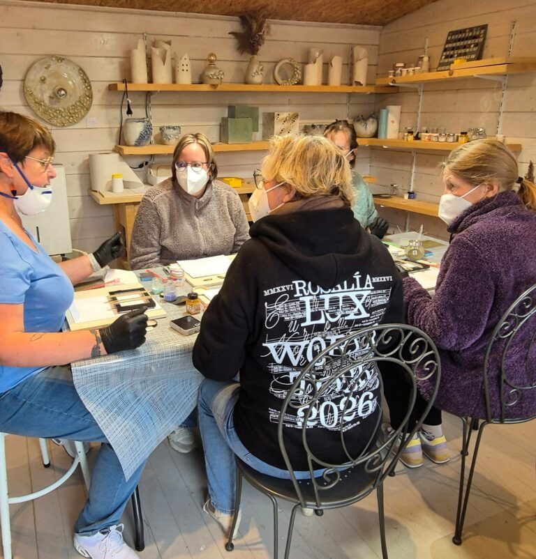 Participantes réunies autour de la table de l'atelier pendant un atelier d'émail sur cuivre