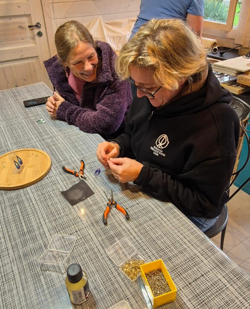 Deux participantes rient en montant leurs boucles d'oreilles à la pince