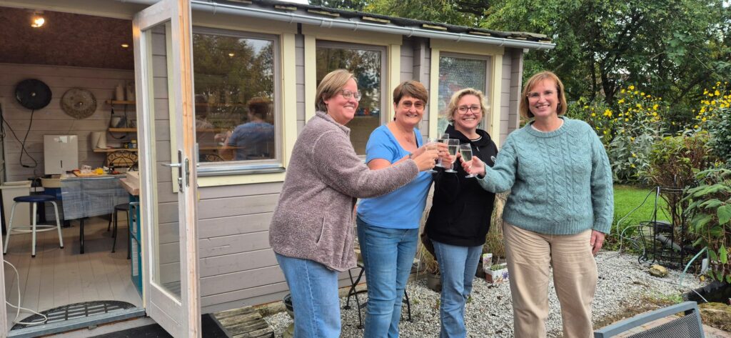 Quatre participantes trinquent devant l'atelier à la fin de la journée