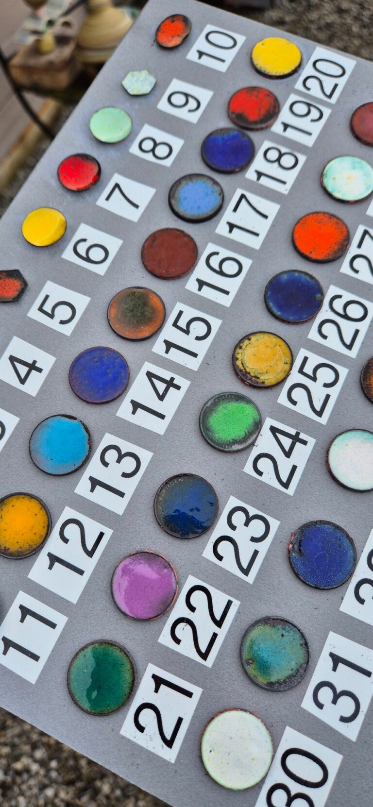 Nuancier d’émaux : pastilles de cuivre émaillées de toutes les couleurs, chacune avec son numéro