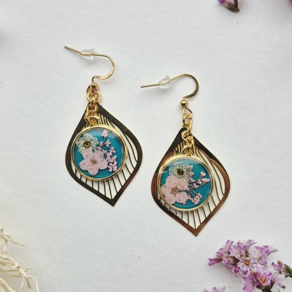 Paire de boucles d'oreilles en résine, fleurs roses et blanches sur fond turquoise, goutte dorée ajourée