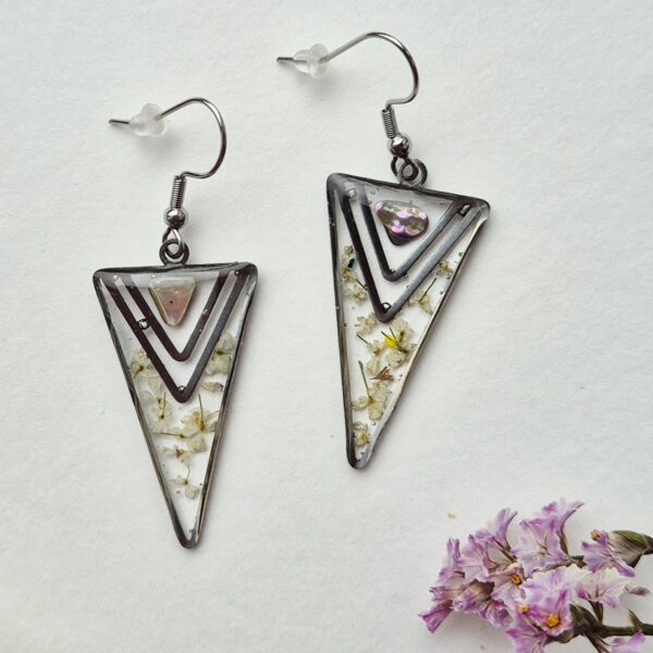 Paire de boucles d'oreilles triangulaires en résine aux petites fleurs blanches et éclat irisé rosé, monture argentée