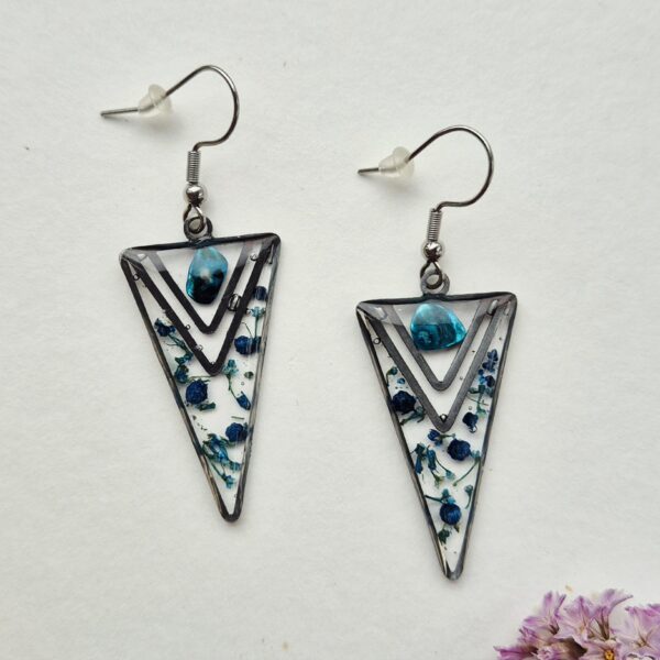 Paire de boucles d'oreilles triangulaires en résine aux petites fleurs bleues et éclat turquoise, monture argentée