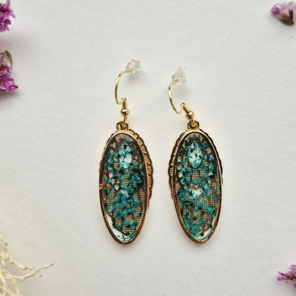 Paire de boucles d'oreilles ovales en résine aux petites fleurs turquoise, cerclées d'or