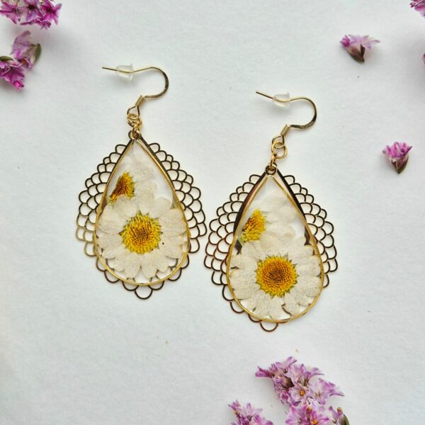 Paire de boucles d'oreilles en résine avec des marguerites séchées, monture dorée en dentelle