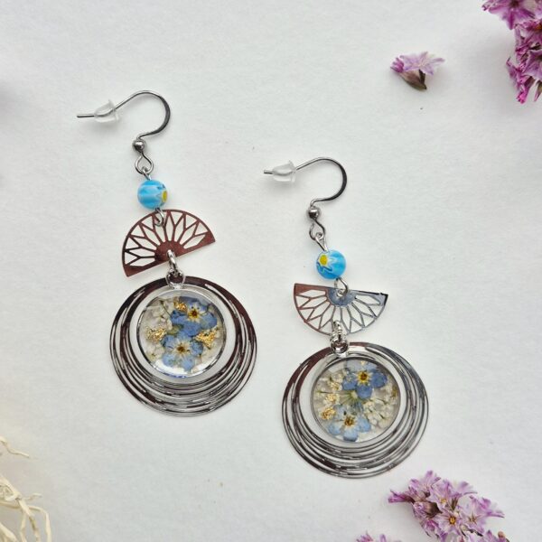 Paire de boucles d'oreilles en résine aux myosotis bleus, médaillon argenté, éventail ajouré et perle bleue