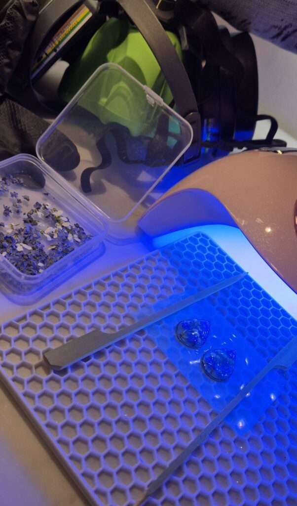 Bijoux en résine en train de durcir sous la lumière bleue de la lampe